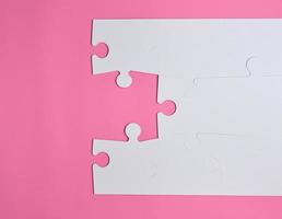 grandes quebra-cabeças brancos em branco sobre um fundo rosa foto