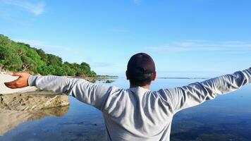 costas do homem usando um chapéu que está olhando para as praias azuis, ilhas e lindo céu azul foto