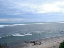 vista da costa de cima, ondas brancas, areia da praia, águas claras e pedras. vista panorâmica. praias bonitas foto