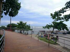 estrada ou ponte ou escadas de madeira na praia, vista da ponte da praia em sayang heulang indonésia foto