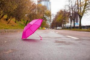 guarda-chuva infantil rosa no asfalto molhado ao ar livre foto