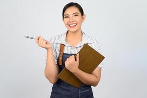 retrato de jovem asiática em pose de uniforme de garçonete com prancheta foto