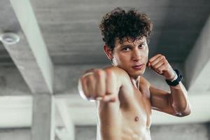 retrato de boxeador de guarda socando para lutar no ginásio foto