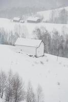 uma abundante nevasca nos cárpatos romenos na aldeia de sirnea, brasov. inverno real com neve no país foto