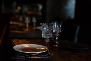 duas taças de champanhe de cristal em uma mesa de madeira escura. foto