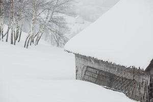 uma abundante nevasca nos cárpatos romenos na aldeia de sirnea, brasov. inverno real com neve no país foto