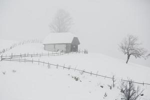 uma abundante nevasca nos cárpatos romenos na aldeia de sirnea, brasov. inverno real com neve no país foto