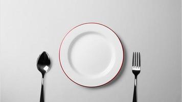 prato, colher e garfo na mesa branca foto