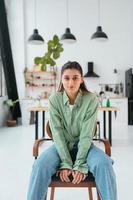 mulher sentada em uma cadeira em uma cozinha moderna foto