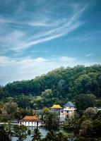 casas perto da água cercadas por árvores sob um céu nublado foto