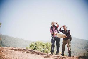 jovem casal de turistas caminhando para uma montanha foto