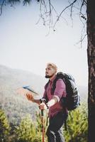 alpinista com mapa e grande viajando para a montanha foto