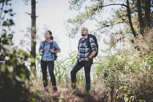 jovem casal aventura caminhando para uma montanha foto