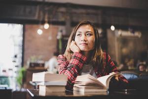 adolescente hipster sentado e lendo um livro em um café foto