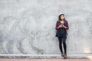 retrato de uma mulher jovem hippie ouvindo música com smartphone foto