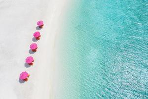 vista aérea da praia de areia branca, espreguiçadeiras guarda-sol perto da lagoa e água do mar turquesa. paisagem de verão sonhadora do resort ou praia do hotel, cenário exótico da visão do drone. férias de luxo foto