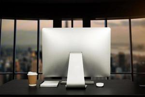 computador do espaço de trabalho colocando na mesa de trabalho de madeira e cercado por uma xícara de café, prancheta, vaso de plantas, pilha de smartphone, tablet e escritório ordenado de teclado. conceito de espaço de trabalho. foto