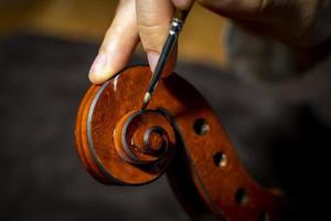 jovem fabricante de violino chinês trabalhando em sua oficina foto