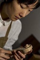 jovem fabricante de violino chinês trabalhando em sua oficina foto