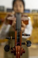 jovem fabricante de violino chinês trabalhando em sua oficina foto