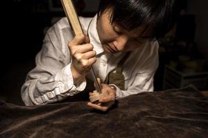 jovem fabricante de violino chinês trabalhando em sua oficina foto