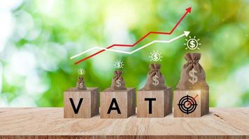 blocos de madeira com as palavras ícone de alvo de iva e bolsa de dinheiro e moedas, conceito de pagamento de impostos, evasão fiscal, tributação, negócios e finanças, planejamento financeiro. foto