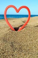 coração vermelho na praia foto