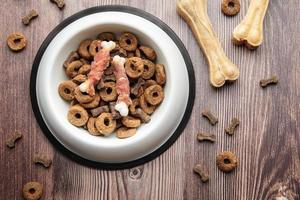 uma tigela de comida de cachorro em um piso de madeira. foto