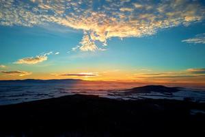 pôr do sol sobre montanhas cobertas de floresta foto