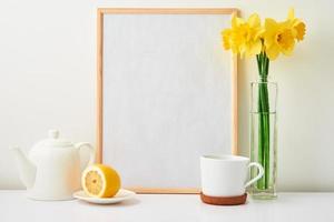 bule, xícara e flores em fundo branco foto