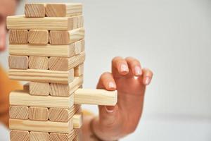 jogo de tabuleiro em família. as mãos pegam o bloco de madeira da torre. foto