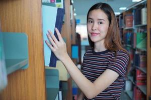 estudantes asiáticos estão na biblioteca da universidade. foto