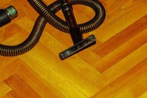 escova de aspirador para coletar poeira de um aspirador em um piso de parquet. foto