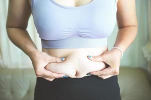 mulher gorda medindo, mulher gorda barriga gorda gordinha esporte recreação saúde perder conceito de gordura da barriga, mulher segurando barriga excessiva foto