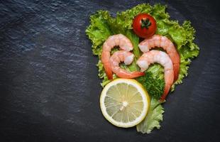 frutos do mar camarões camarões cozidos com tomate limão e salsa em alface vegetal foto