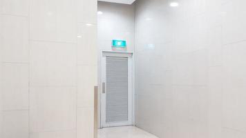 uma porta branca de saída de emergência no prédio do shopping foto