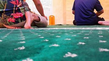 pessoas muçulmanas rezando juntas em uma sala de oração em um shopping. tapete verde ou tapete de oração. foto