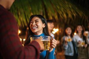 retrato de amigos asiáticos felizes jantando juntos - jovens brindando copos de cerveja jantar ao ar livre - pessoas, comida, estilo de vida de bebida, conceito de celebração de ano novo. foto