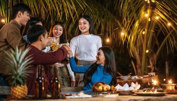 retrato de amigos asiáticos felizes jantando juntos - jovens brindando copos de cerveja jantar ao ar livre - pessoas, comida, estilo de vida de bebida, conceito de celebração de ano novo. foto