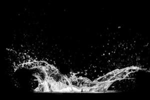 espirrando água em um fundo preto. respingos de água refrescante fundo preto foto