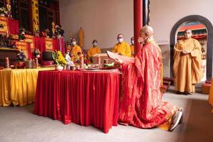 bandung, indonésia, 2020 - os monges com roupas laranja rezam juntos em frente ao altar foto