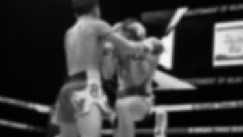 imagens desfocadas estilo de foto em preto e branco de boxe tailandês ou muay thai ou kickboxing, que boxeadores locais e estrangeiros estão lutando no ringue no palco interno como esporte de arte marcial. boxe muay thai