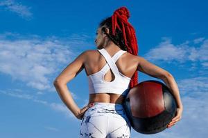 céu de fundo. de trás. mulher atlética com bola médica. força e motivação. foto de mulher esportiva em roupas esportivas da moda