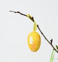 ovo decorativo amarelo de lantejoulas em um fundo branco foto