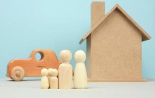 casa de madeira e carro com figuras familiares em miniatura, conceito de hipoteca e empréstimo foto