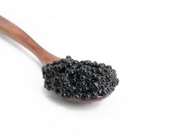 caviar fresco granulado preto paddlefish na colher de madeira marrom no fundo branco, fechar foto