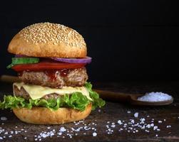 hambúrguer duplo com queijo, fundo preto foto