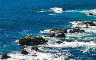 belas rochas falésias ver ondas na praia puerto escondido méxico. foto