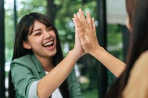 jovem mulher e amiga fazendo high five com prazer foto