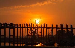 belo pôr do sol com a silhueta da ponte u bein, região de mandalay em myanmar. foto